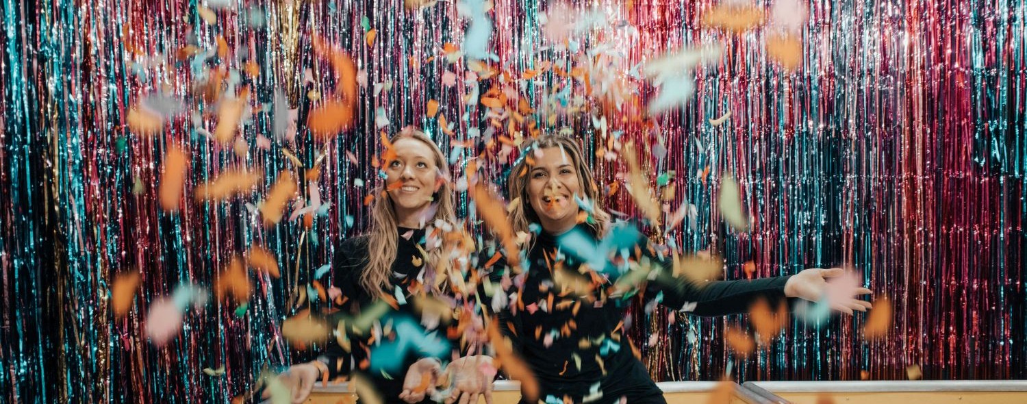 two women with confetti falling on them